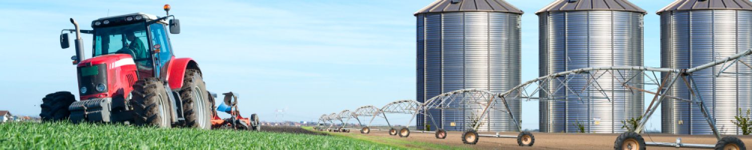 agriculture-and-food-production-concept-with-tractor-machine-silos-and-irrigation-system